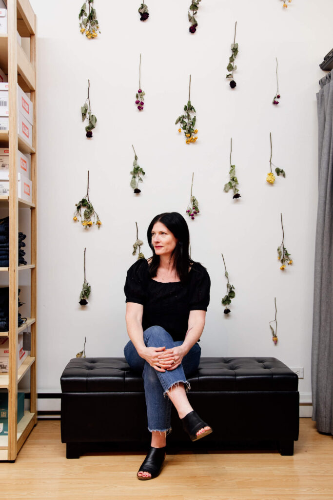 A shop owner sitting on a stool in her store in Victoria, BC.