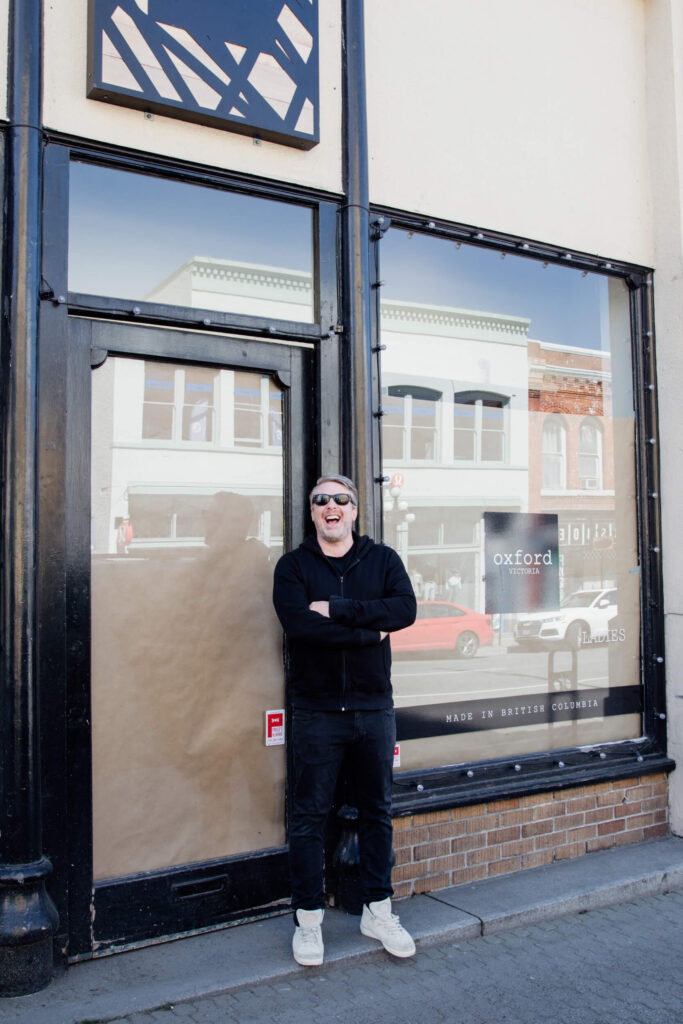 A shop owner laughing in front of his shop in Victoria, Canada.