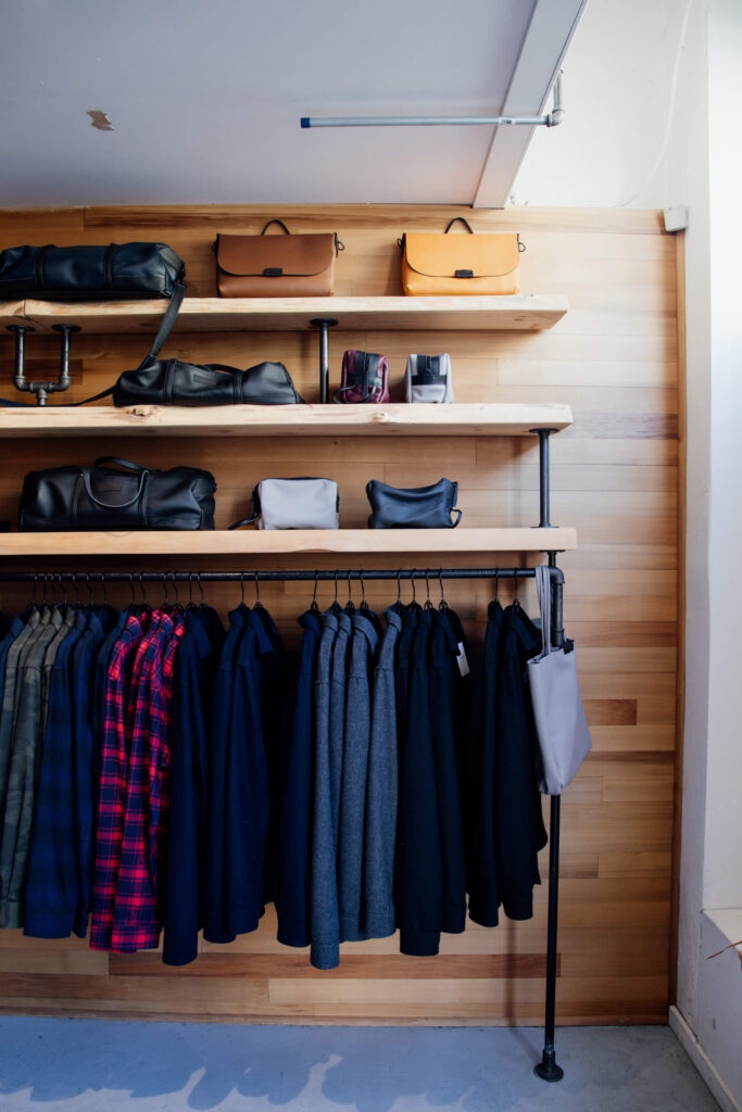 Clothes and bags hanging on a rack in a clothing shop in Victoria, Canada.