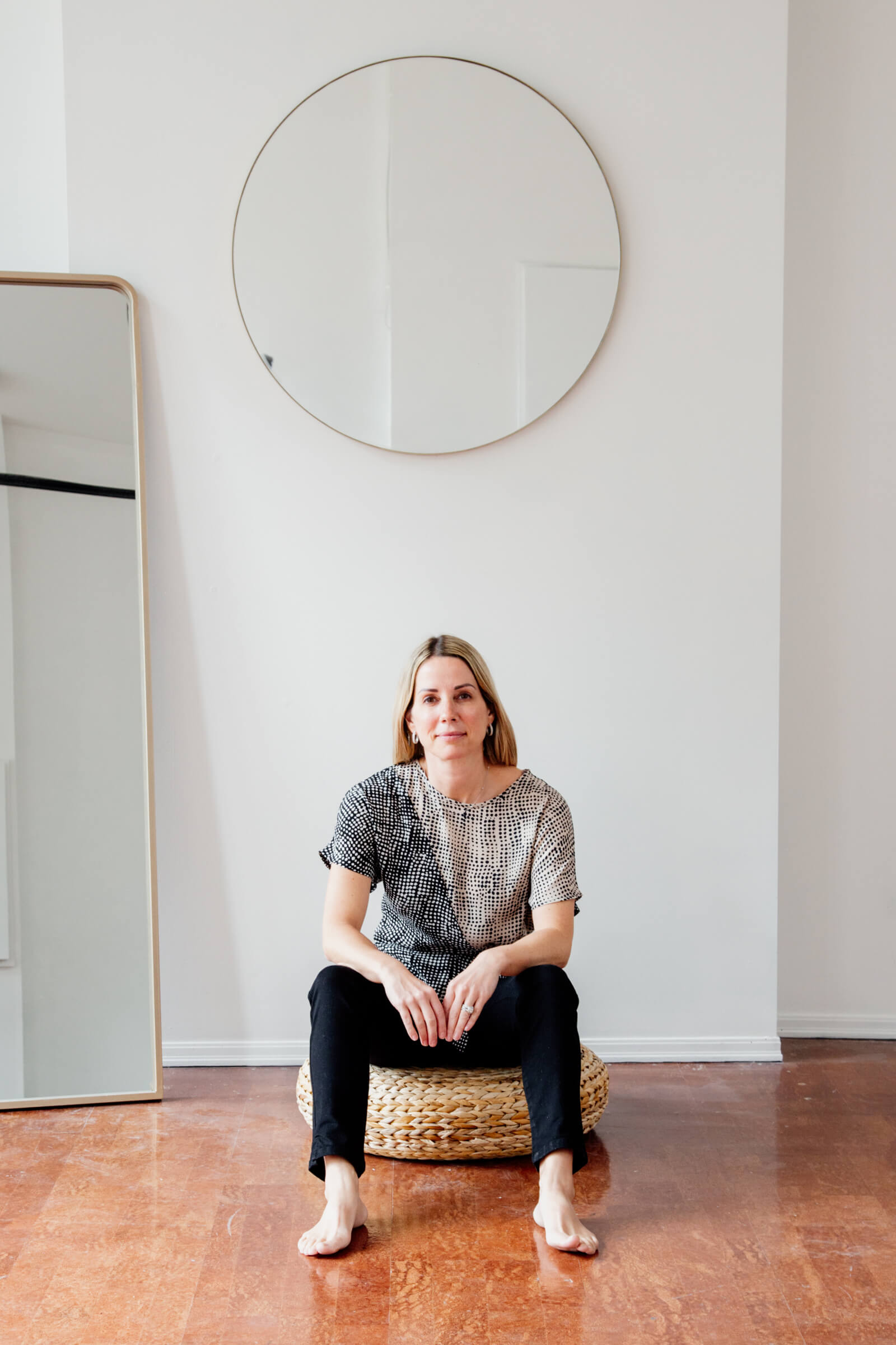 Woman sitting on a cushion on the floor.