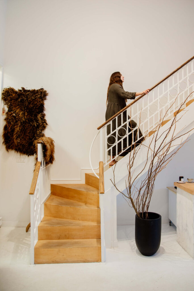 Shop owner walking up stairs to second level of her shop.