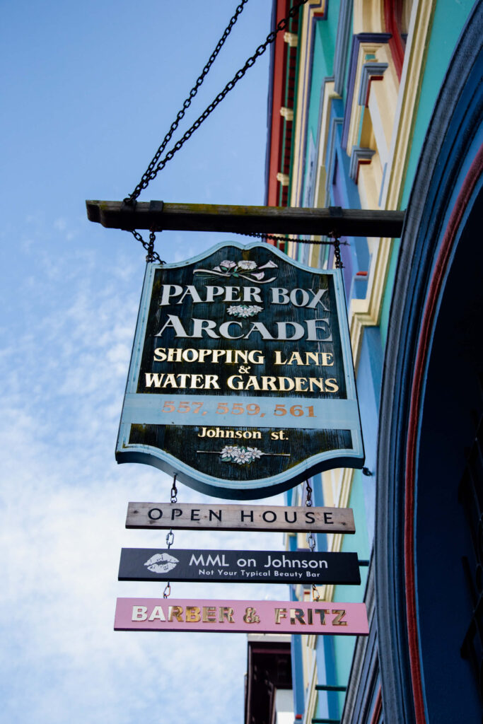 A sign on the street directing people to a row of shops.