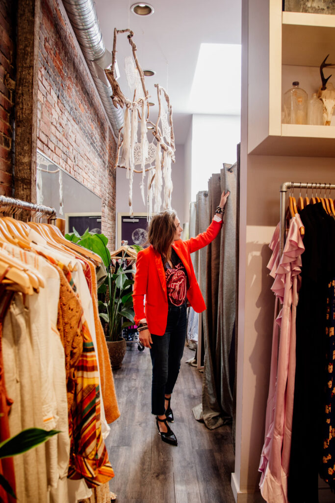 A shopowner tidies up the change rooms in her shop.