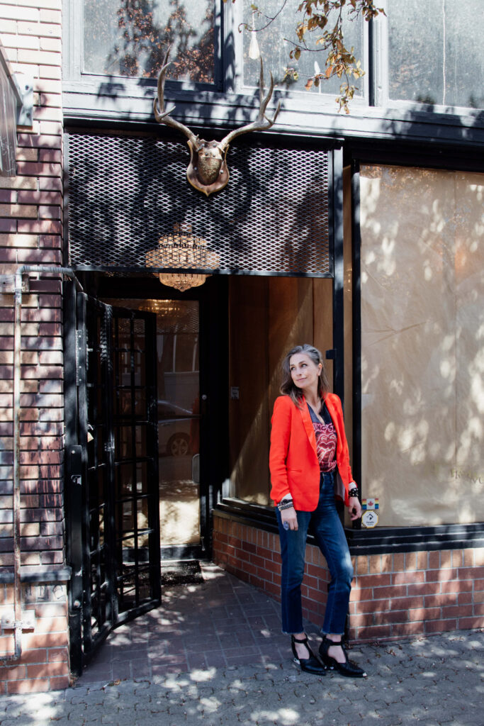 A shopowner stands outside her store.