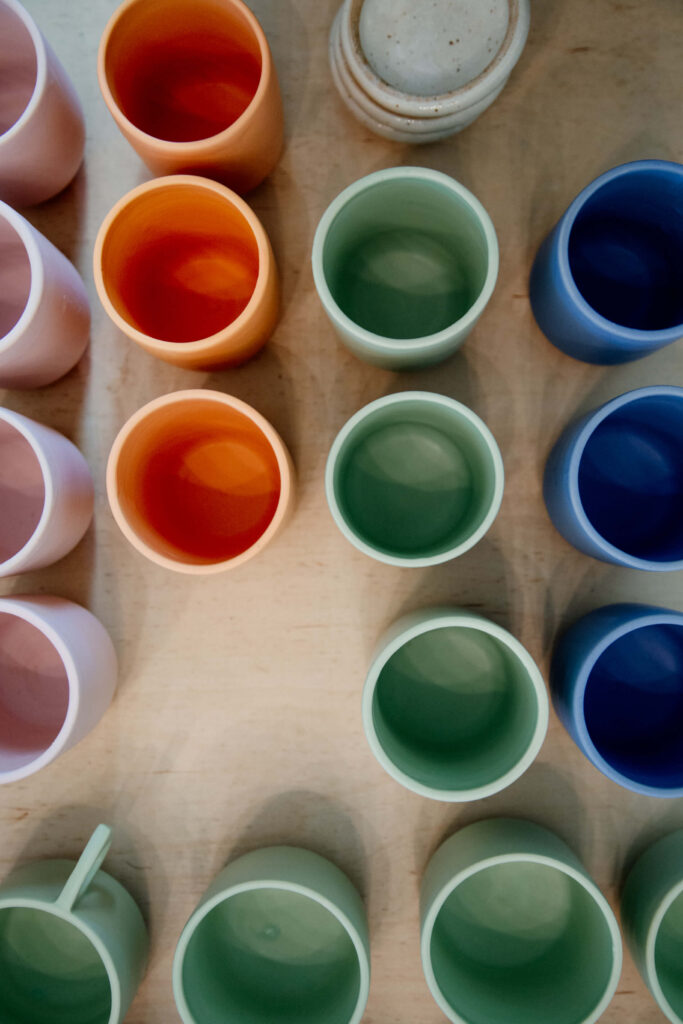 Colourful ceramic mugs on display at a shop.