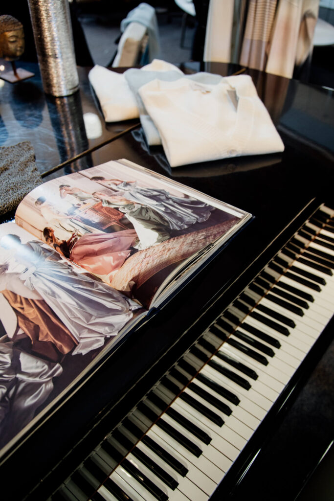 A fashion book opened a top a grand piano.