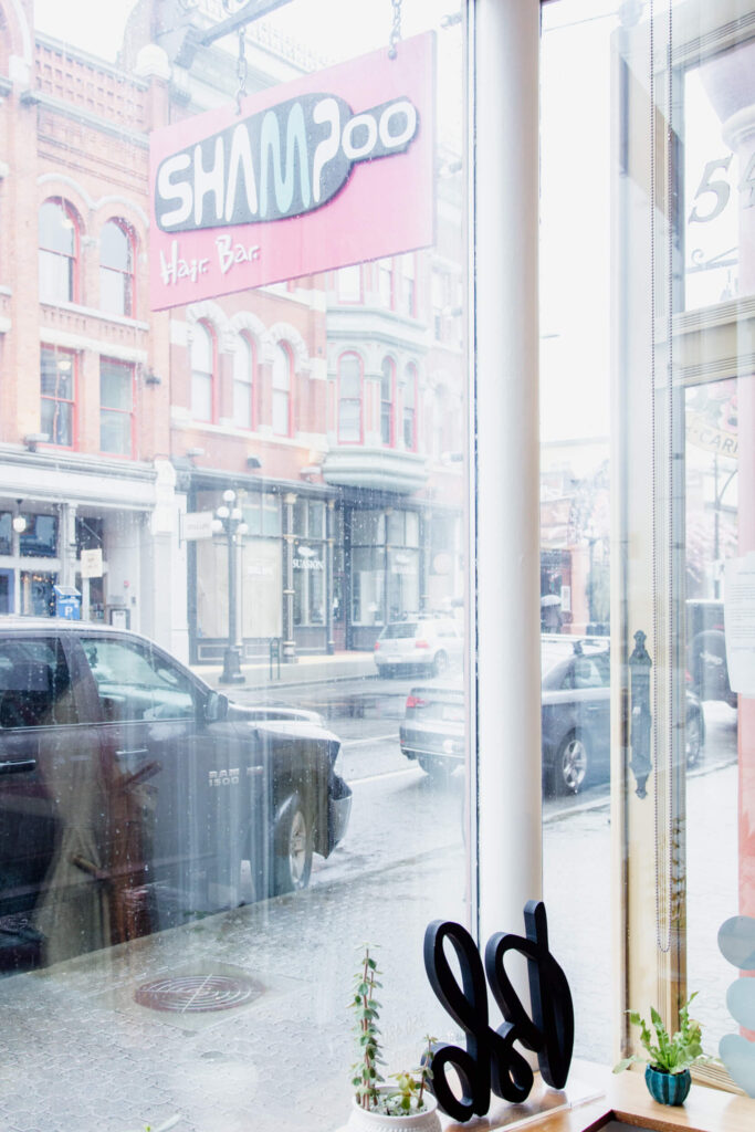 The view through salon windows to a rainy street.