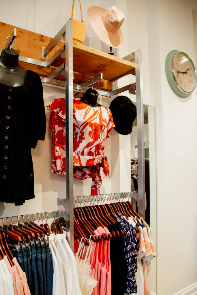 Shirts and jeans on a rack in a boutique shop.