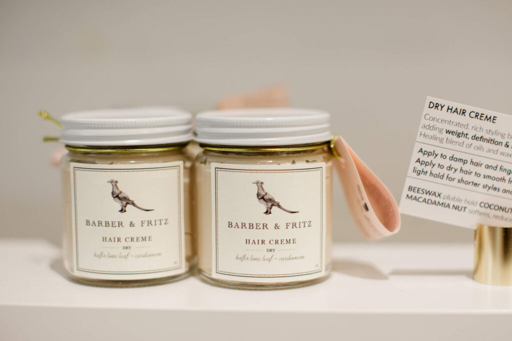 Jars of hair product on a shelf.