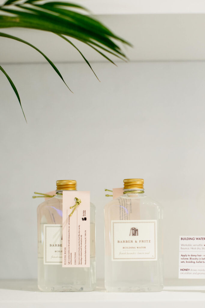 Bottles of hair product on a shelf.