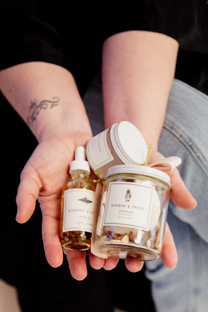 Hair products in jars held in a salon owner's hands.