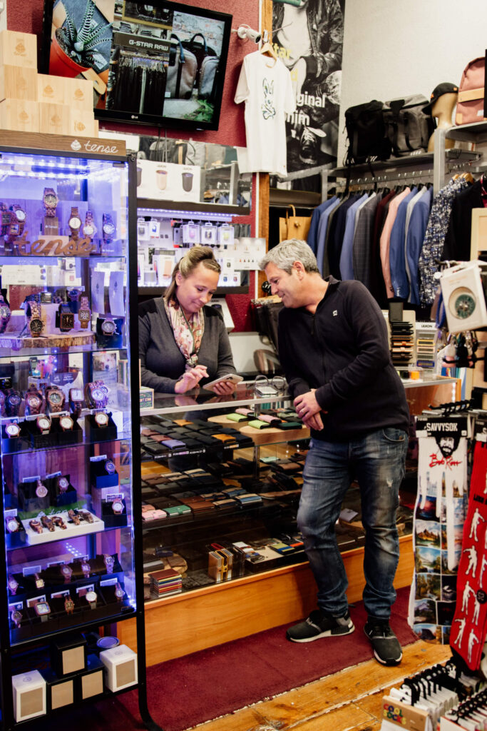 A couple of shop owners look over some numbers at their cash desk.