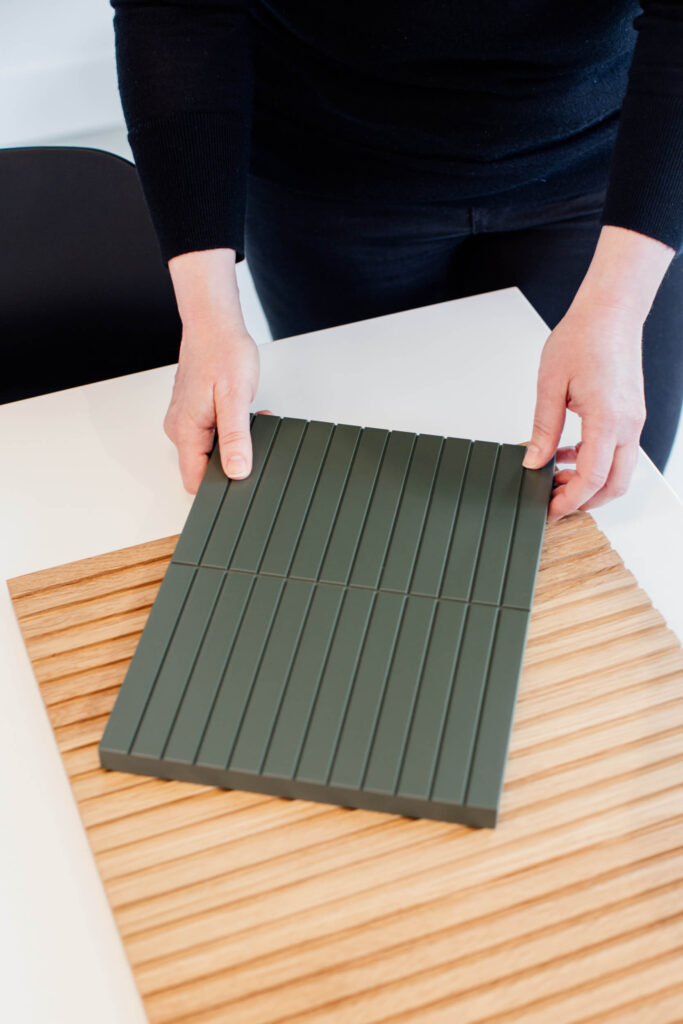 A designers picks up cabinet fronts on a table in a shop in  Victoria, BC.