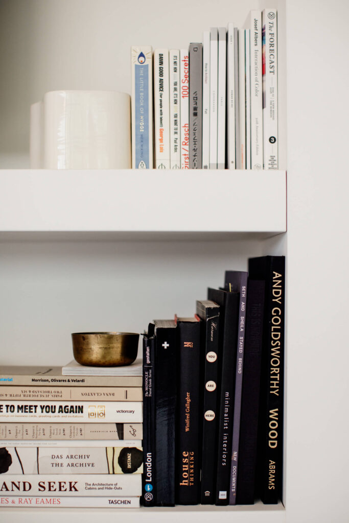 Books on a shelf in studio in Victoria, BC.