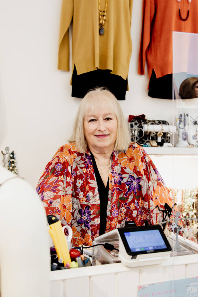 A shopkeeper stands behind the counter in her shop in Victoria BC.