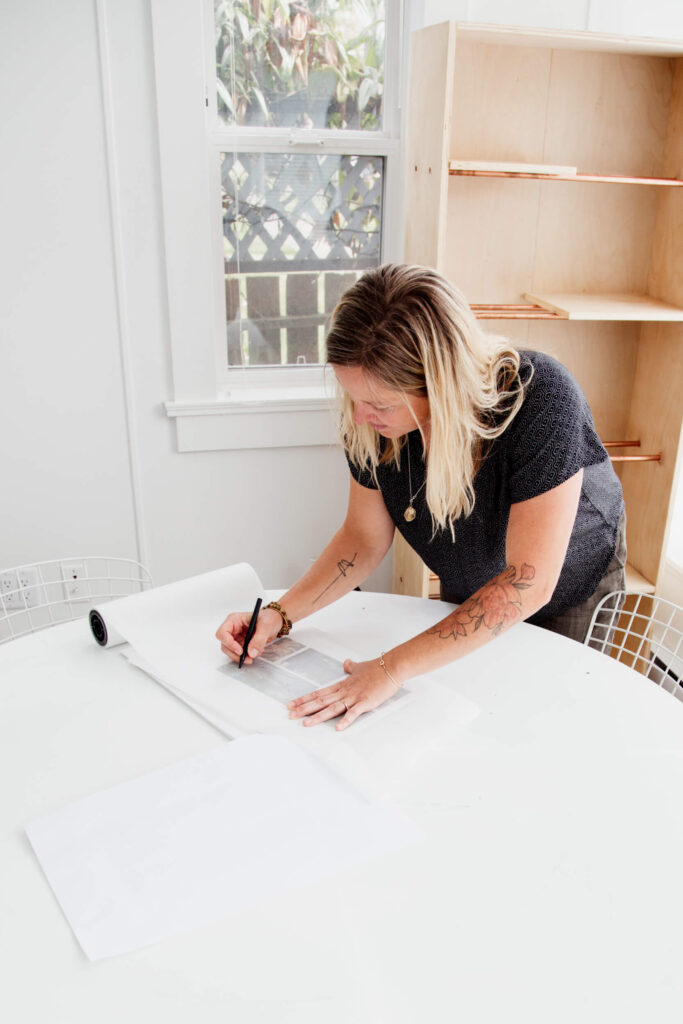 A architect draws a plan on a table.