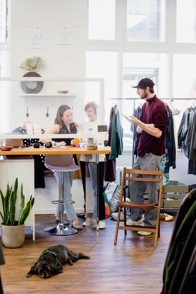 Business partners discuss ideas behind their front counter in a consignment shop in Victoria, BC.