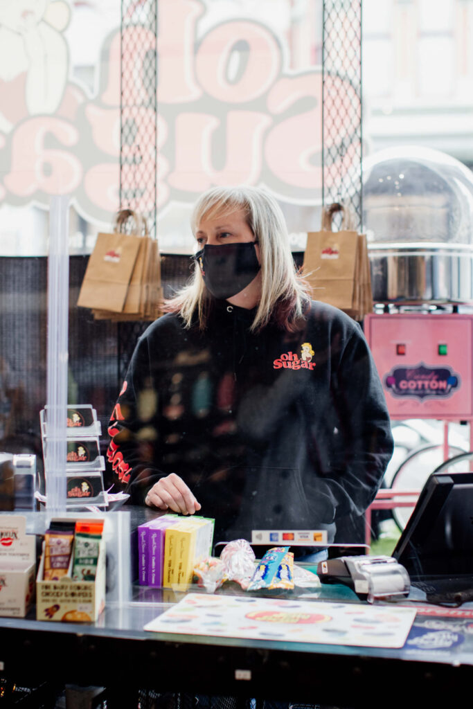 A shop owner behind the counter in her store.